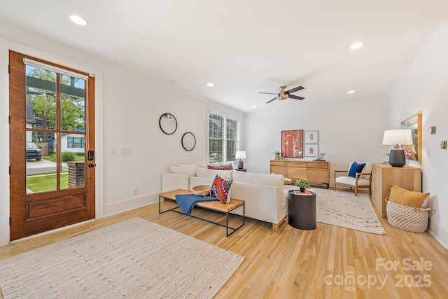 living room with baseboards, plenty of natural light, and light wood-style flooring