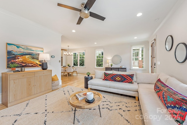 living room with crown molding, recessed lighting, wood finished floors, and ceiling fan with notable chandelier