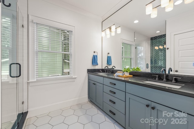 bathroom with double vanity, baseboards, a sink, and a stall shower