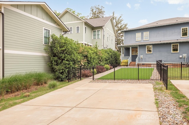 exterior space featuring covered porch, board and batten siding, a yard, and a fenced front yard