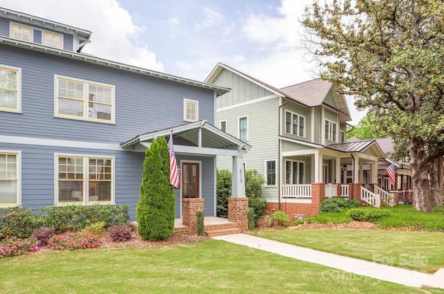 view of front of property featuring a porch, board and batten siding, and a front yard
