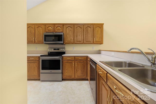 kitchen featuring light countertops, stainless steel appliances, brown cabinets, and a sink