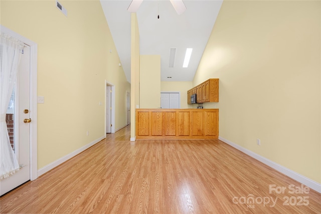 unfurnished living room featuring ceiling fan, light wood-style floors, high vaulted ceiling, baseboards, and visible vents