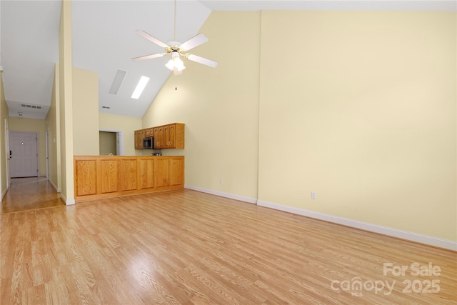 unfurnished living room with ceiling fan, visible vents, high vaulted ceiling, baseboards, and light wood finished floors