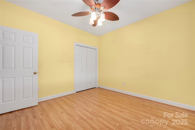 unfurnished bedroom with baseboards, ceiling fan, light wood-style flooring, and a closet