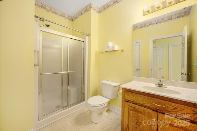 full bathroom with vanity, baseboards, a stall shower, and toilet