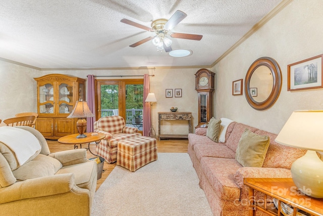 living room with a textured ceiling, ornamental molding, light wood-type flooring, and ceiling fan