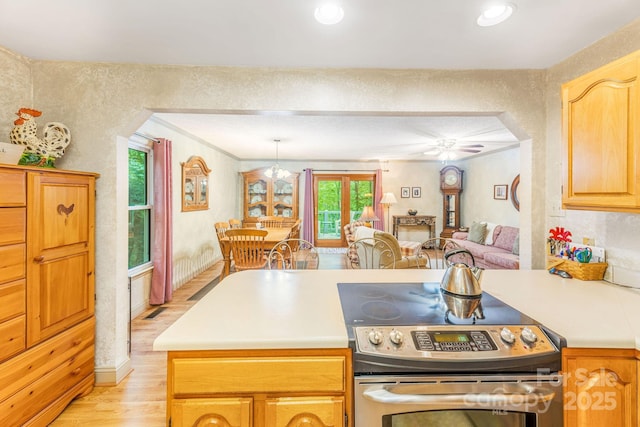 kitchen with electric stove, light wood finished floors, light countertops, and plenty of natural light