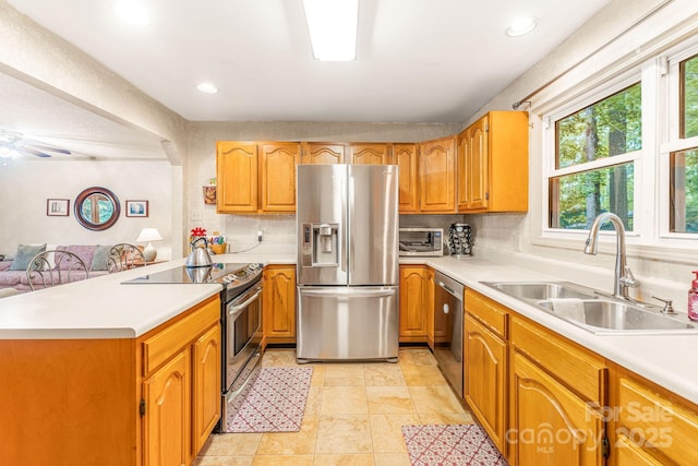 kitchen with stainless steel appliances, a sink, light countertops, and recessed lighting