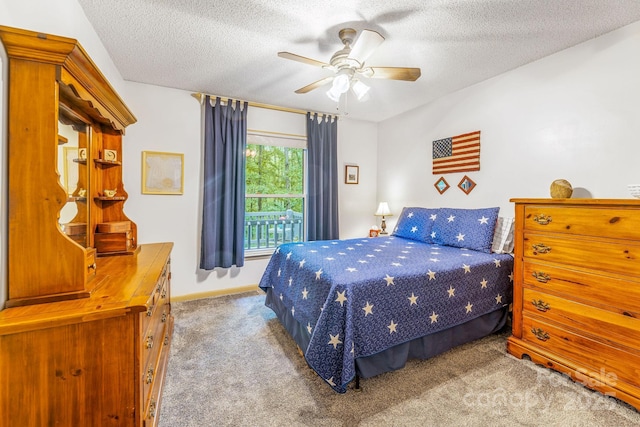 carpeted bedroom featuring a textured ceiling, a ceiling fan, and baseboards