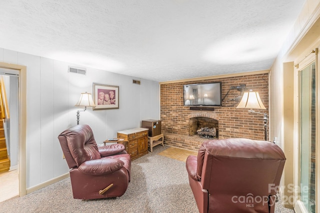 living area with a textured ceiling, a brick fireplace, and carpet