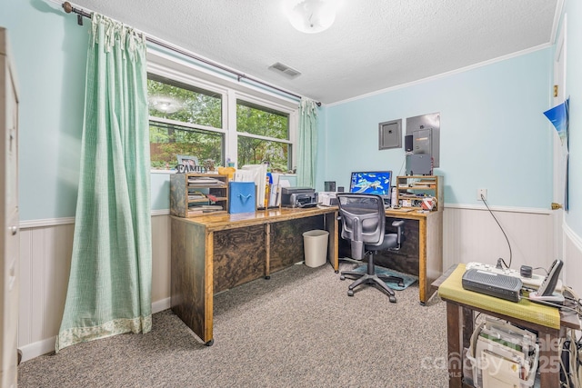 carpeted office with a textured ceiling, a wainscoted wall, crown molding, and electric panel
