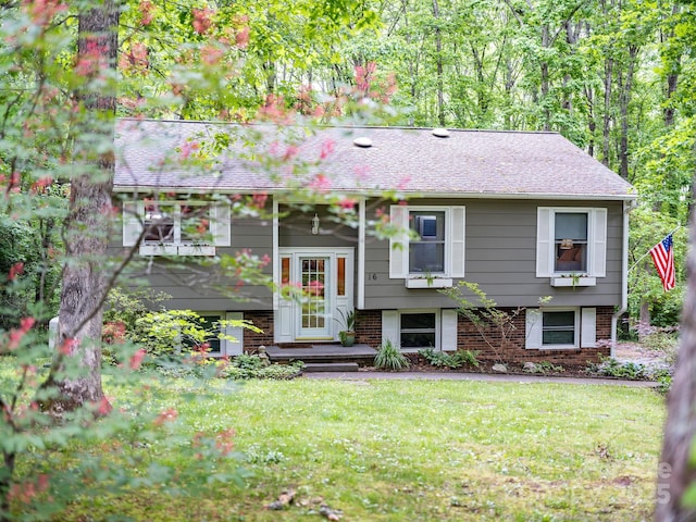 bi-level home featuring brick siding and a front lawn