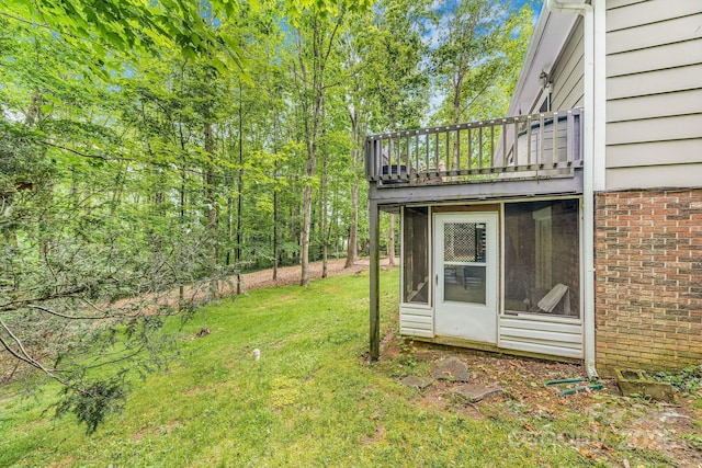 view of grassy yard featuring a balcony