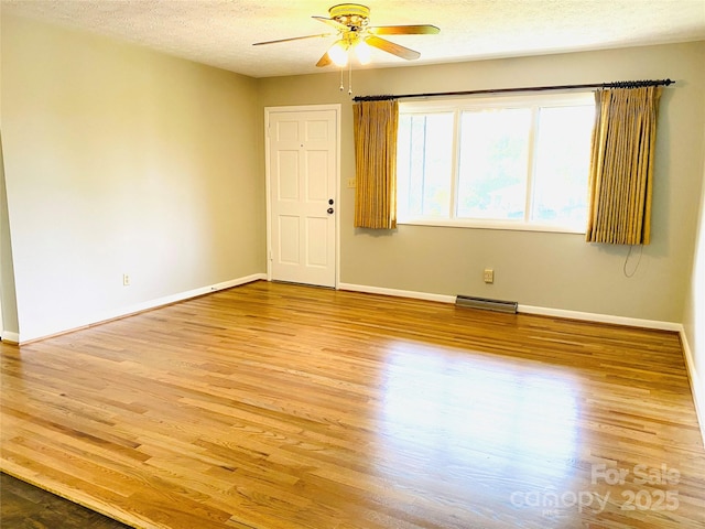 spare room featuring light wood-type flooring, baseboards, ceiling fan, and visible vents