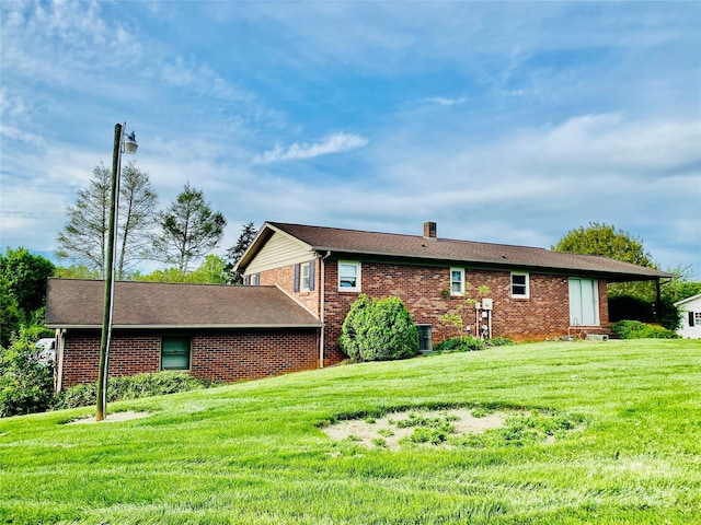 rear view of house with a yard and brick siding