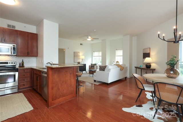 721 Governor Morrison St Unit 520, Charlotte, NC 28211 - kitchen featuring stainless steel appliances, a peninsula, open floor plan, a chandelier, and a kitchen breakfast bar