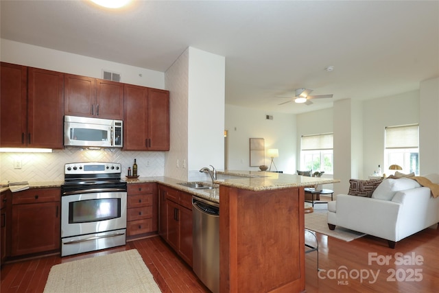 721 Governor Morrison St Unit 520, Charlotte, NC 28211 - kitchen featuring stainless steel appliances, a sink, open floor plan, a peninsula, and dark wood finished floors