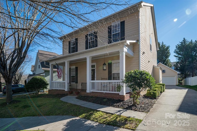 view of front of house featuring an outdoor structure, covered porch, and a detached garage