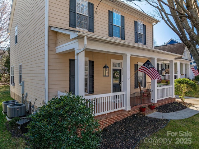 traditional home with central air condition unit and a porch
