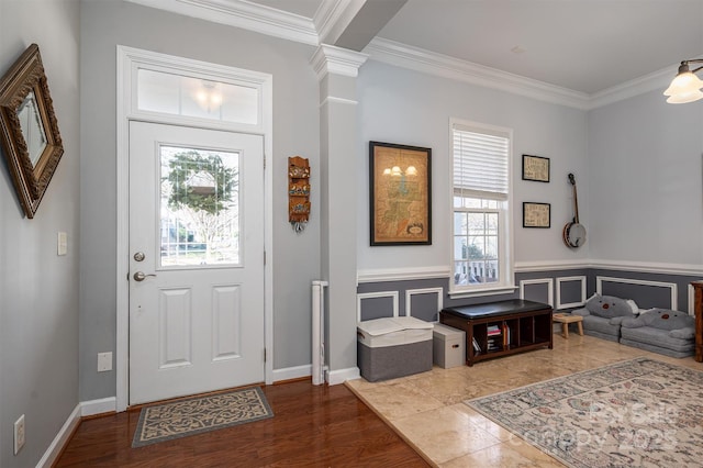 entrance foyer with ornamental molding, wood finished floors, and a wainscoted wall