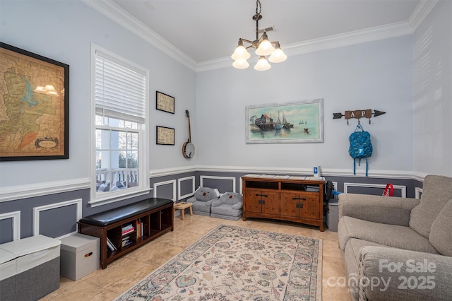 living area with crown molding, a notable chandelier, wainscoting, a decorative wall, and visible vents