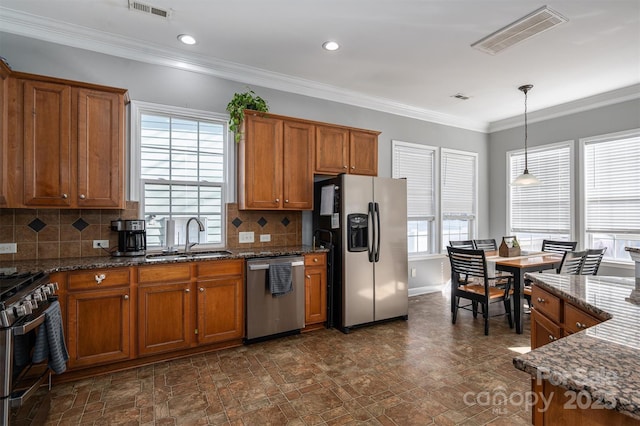 kitchen featuring brown cabinets, appliances with stainless steel finishes, a sink, and visible vents