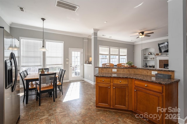 kitchen featuring visible vents, brown cabinetry, ceiling fan, and stainless steel fridge with ice dispenser