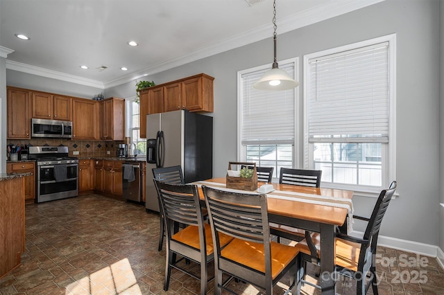 kitchen featuring appliances with stainless steel finishes, plenty of natural light, backsplash, and brown cabinets