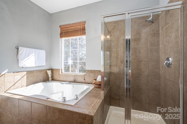 bathroom featuring a jetted tub and a stall shower