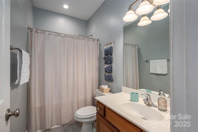 bathroom featuring toilet, curtained shower, and vanity