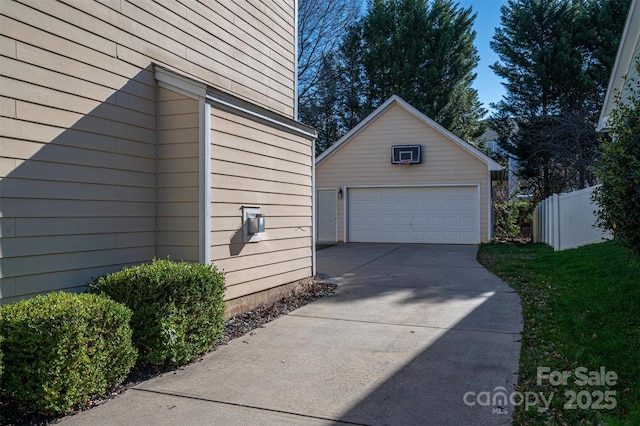 view of home's exterior featuring fence, an outbuilding, and a garage