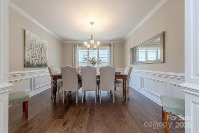 dining room featuring crown molding, an inviting chandelier, and a decorative wall