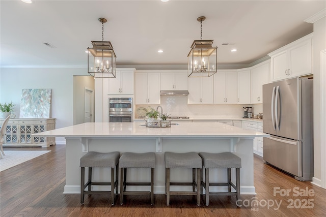 kitchen featuring an inviting chandelier, white cabinetry, under cabinet range hood, and stainless steel appliances
