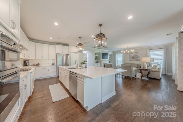 kitchen featuring light countertops, stainless steel appliances, an inviting chandelier, and a sink