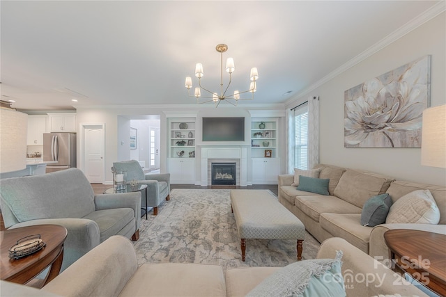 living room with crown molding, built in features, plenty of natural light, and a chandelier