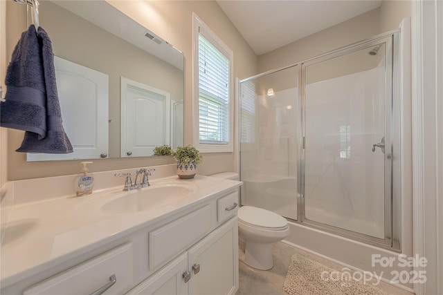 bathroom featuring toilet, visible vents, a shower stall, and vanity