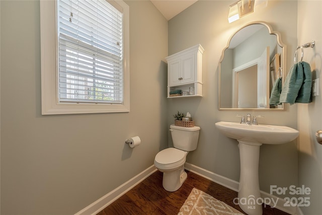 bathroom with baseboards, a sink, wood finished floors, and toilet