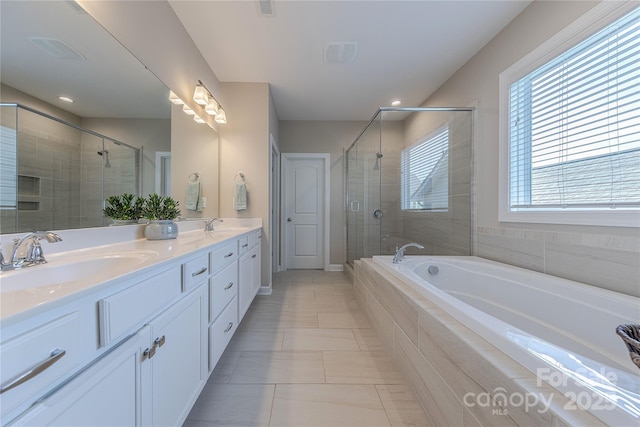 full bathroom with a sink, a stall shower, and a garden tub
