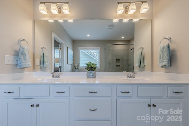 bathroom with double vanity, a sink, and a shower stall