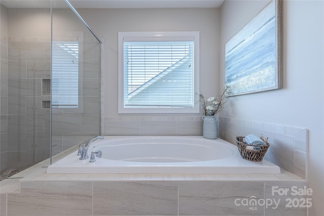 bathroom featuring tiled shower and a bath