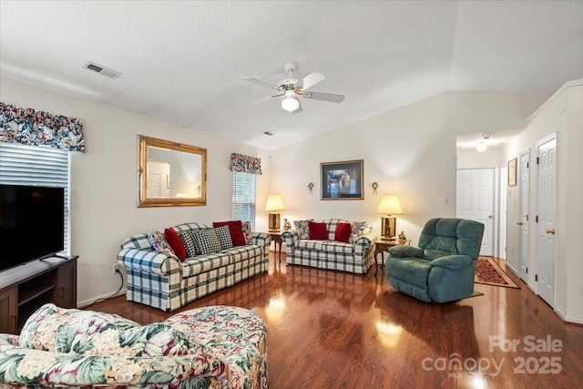 living room featuring visible vents, wood finished floors, baseboards, ceiling fan, and vaulted ceiling