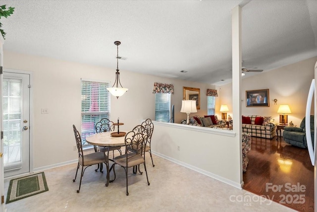 dining area with a textured ceiling, ceiling fan, visible vents, and baseboards