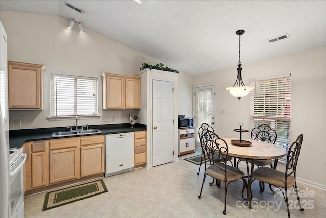 kitchen featuring white appliances, light brown cabinetry, visible vents, and a sink