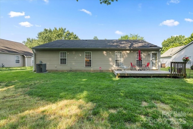 rear view of house featuring central air condition unit, a wooden deck, and a lawn
