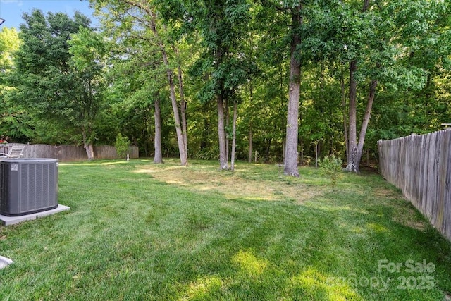 view of yard featuring central AC and fence