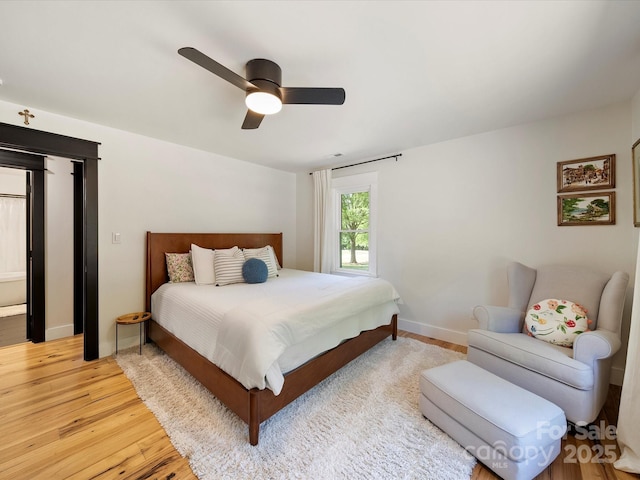 bedroom with light wood-style floors, baseboards, and a ceiling fan