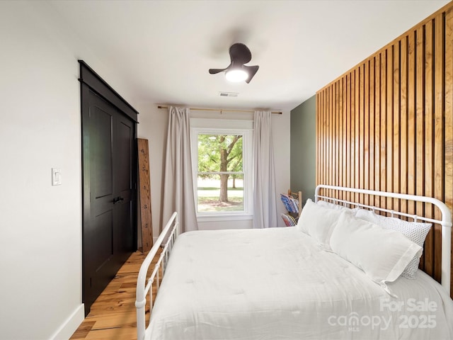 bedroom with visible vents, baseboards, ceiling fan, and light wood-type flooring