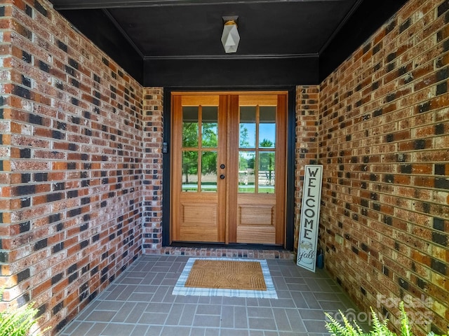 property entrance with brick siding and french doors