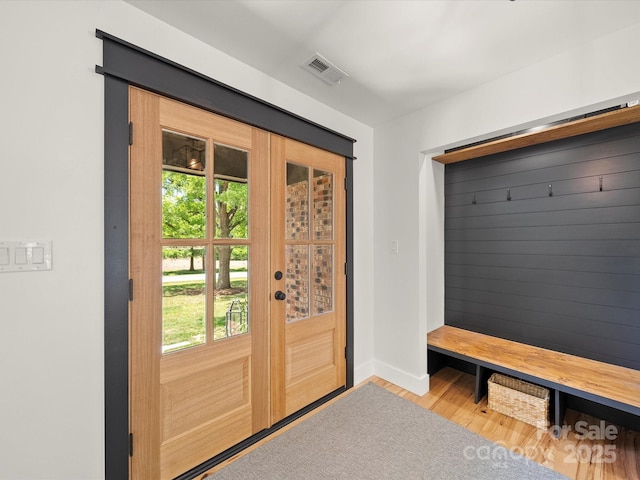 mudroom with baseboards, a wealth of natural light, wood finished floors, and visible vents